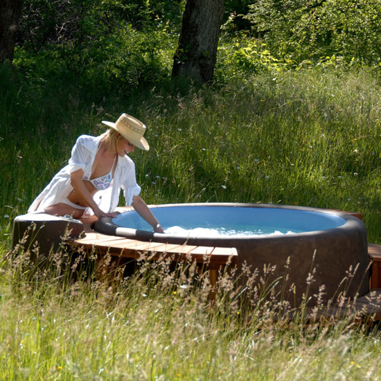 A Softub hot tub in a garden setting