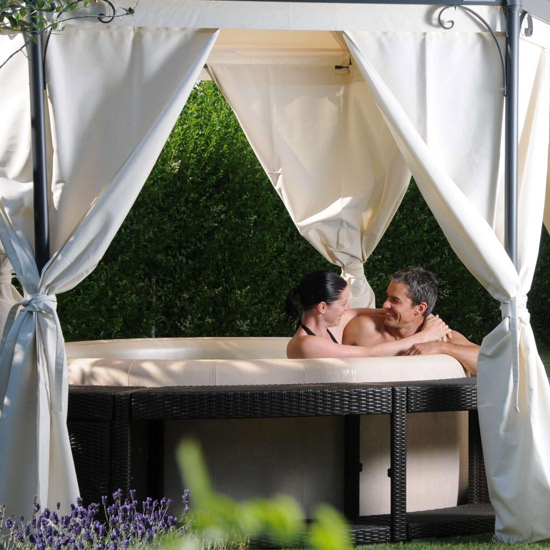 A Softub hot tub in a garden setting