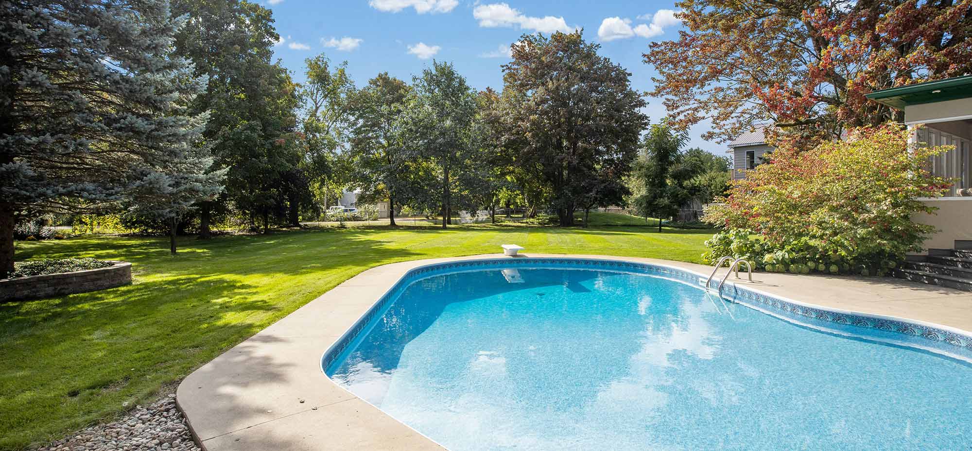 A lined swimming pool in a lawned garden